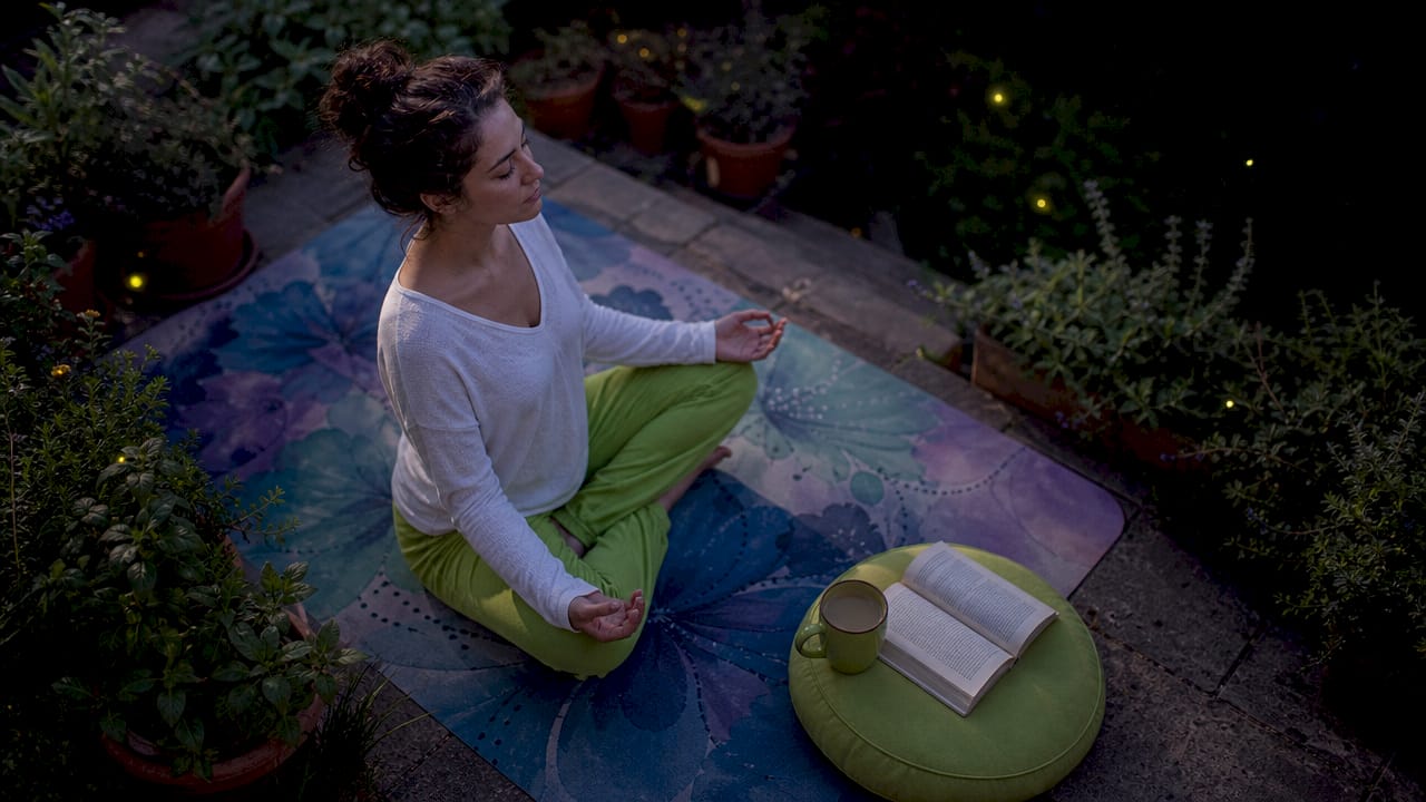Woman meditating with herbal tea at home