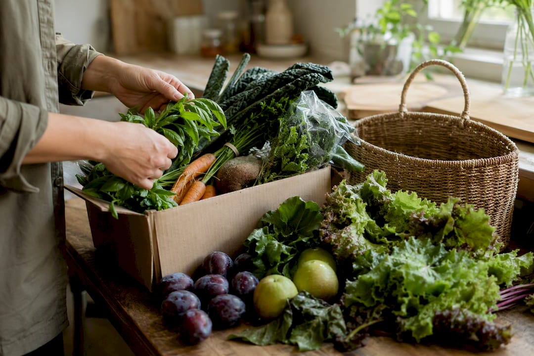 Hands unpacking fruit and vegetable box