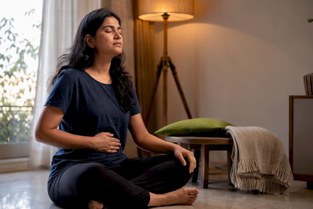 Person practicing calm breathing at home
