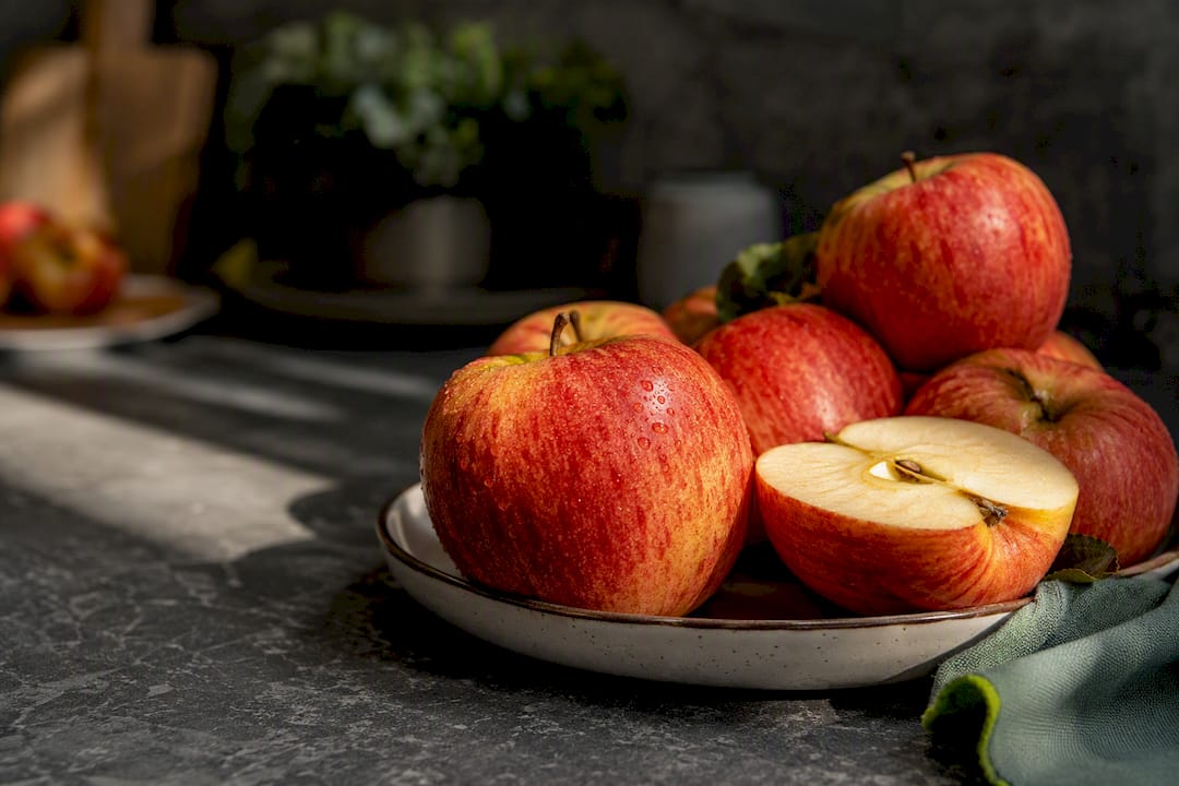Unpeeled organic apples in dramatic kitchen light